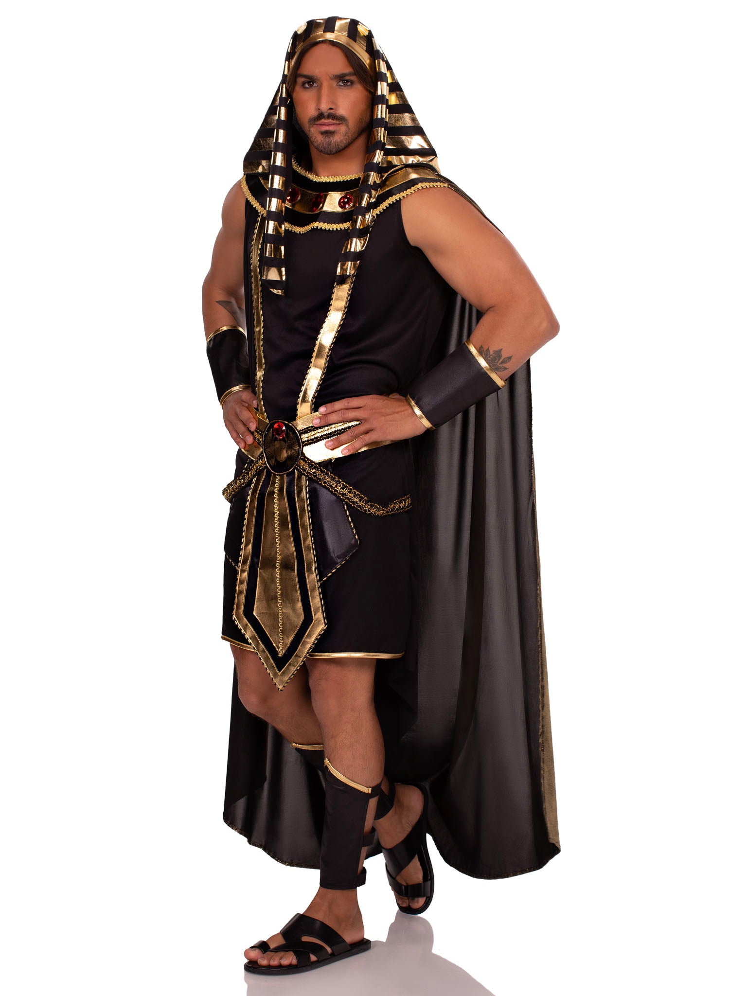 Man in gold-black Pharaoh costume with striped headdress, jeweled collar, cape, belt, cuffs, leg guards.
