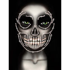 Glow in the Dark Skull Face Jewels Sticker forms rhinestone skull over a face with green eyes