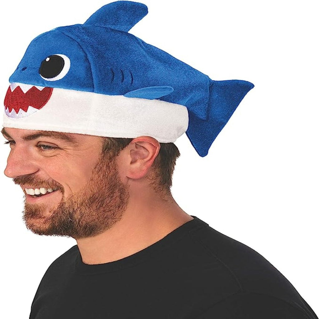 Rubie's Baby Shark Hat with Original Song Sound Chip, blue plush shark hat with white belly worn by man.
